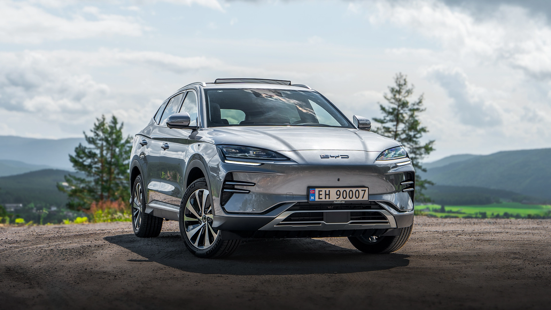 BYD Seal U i sølvfarge parkert med utsikt over dal og fjell – elektrisk SUV til salgs hos Granrud Bilverksted.