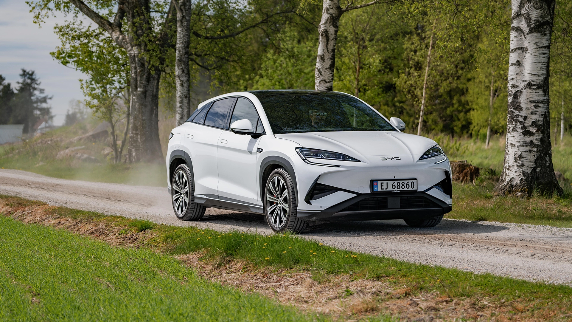BYD Sealion 7 kjører på grusvei gjennom skog – elektrisk SUV fra Granrud Bilverksted.