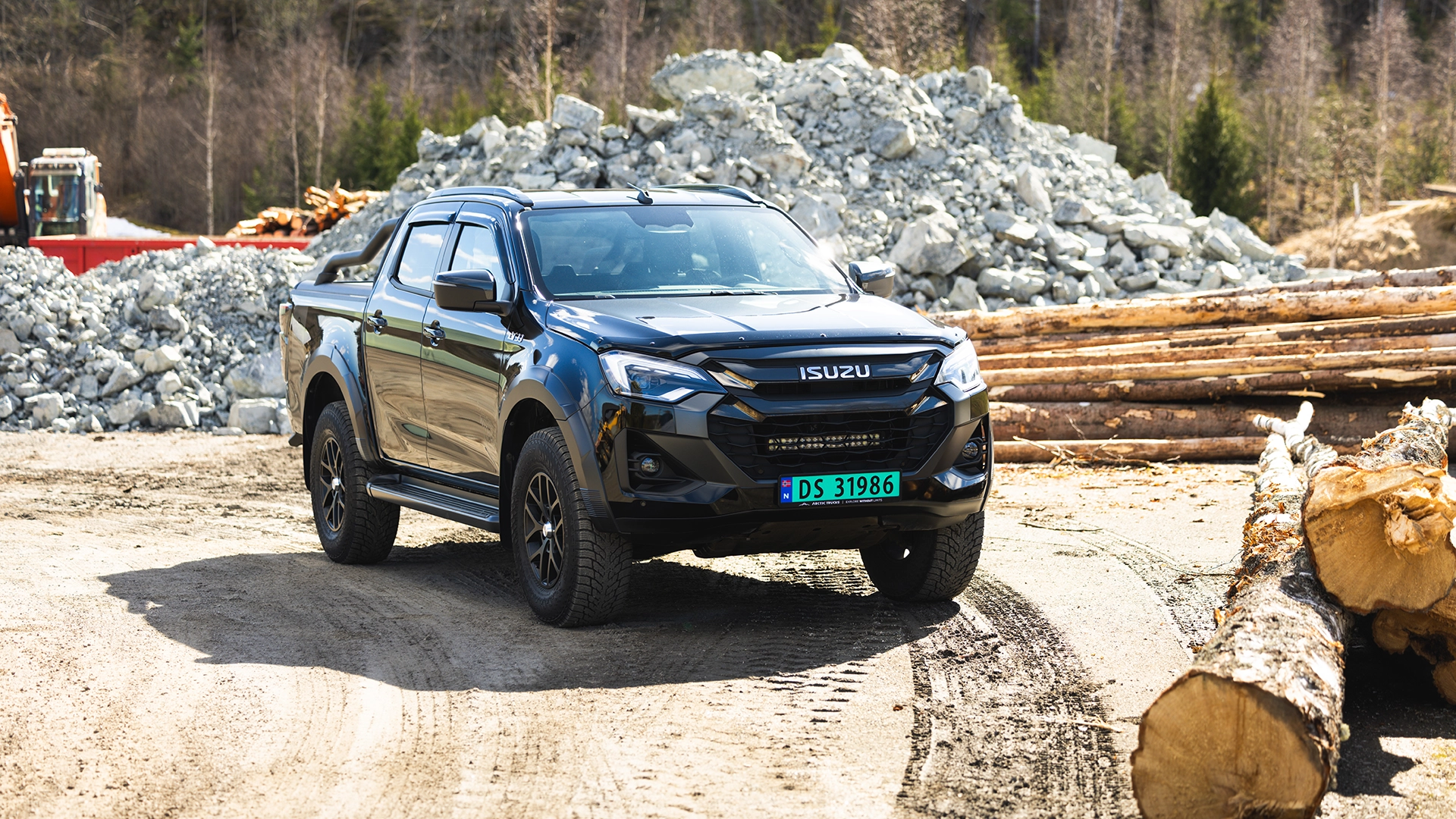 Svart Isuzu D-MAX pickup i arbeidsterreng – robust nyttekjøretøy hos Granrud Bilverksted.