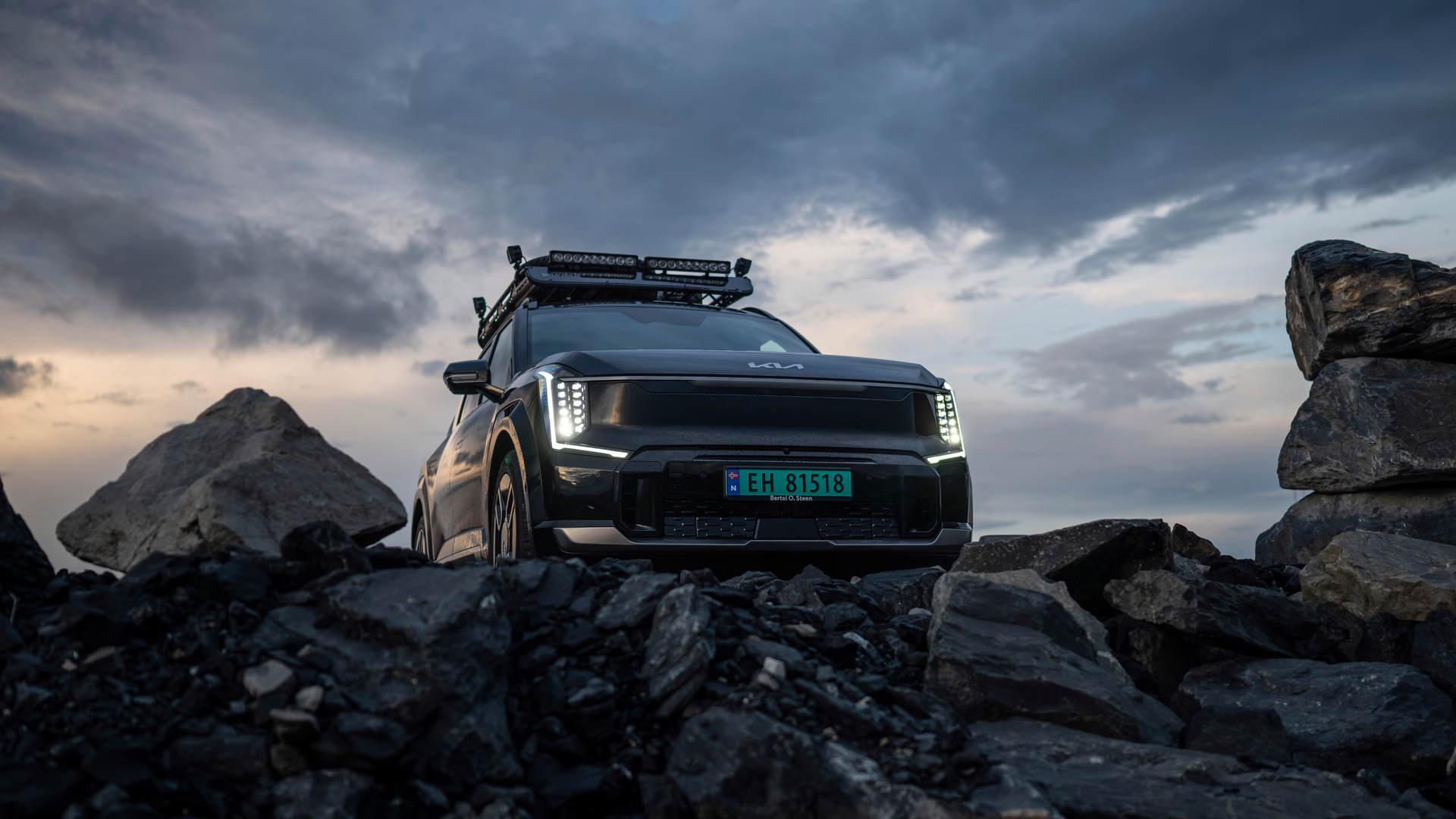 Svart Kia EV9 med ekstralys og takstativ i røft terreng – robust elektrisk SUV fra Granrud Bilverksted.