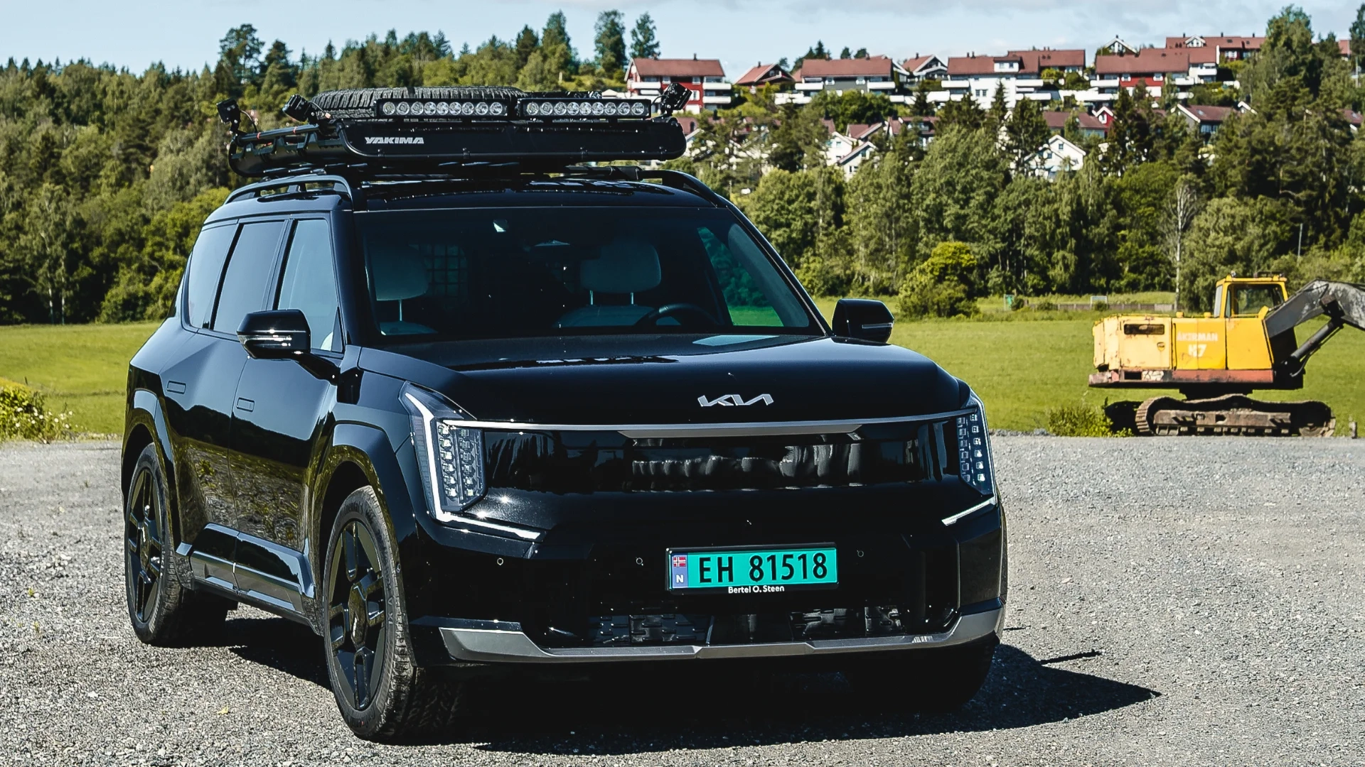Svart Kia EV9 med takstativ parkert foran boligfelt – allsidig el-SUV hos Granrud Bilverksted.